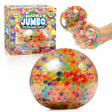 The jumbo rainbow squishy stress ball next to it's packaging with a hand squeezing on another stress ball.